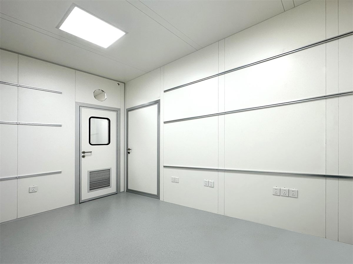 Interior of an electronics cleanroom with smooth antistatic wall panels, a cleanroom door and flush ceiling lighting